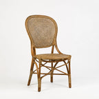 Sika Rossini Rattan Side Chair with curved rattan frame and woven cane back and seat in natural brown.