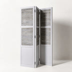 Whitehaven Room Divider in distressed antique white mango wood with hinged louvered panels.