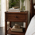 Plantation 1 Drawer Bedside with woven rattan, featuring a ceramic bowl atop stacked books and a glass vase of greenery.