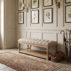 Oakfield Bench with tufted upholstery and sculpted oak frame set against paneled walls with botanical prints.
