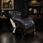 The Huntsman Chair in South American top-grain leather with cowhide detailing and saddle straps in a dark study.
