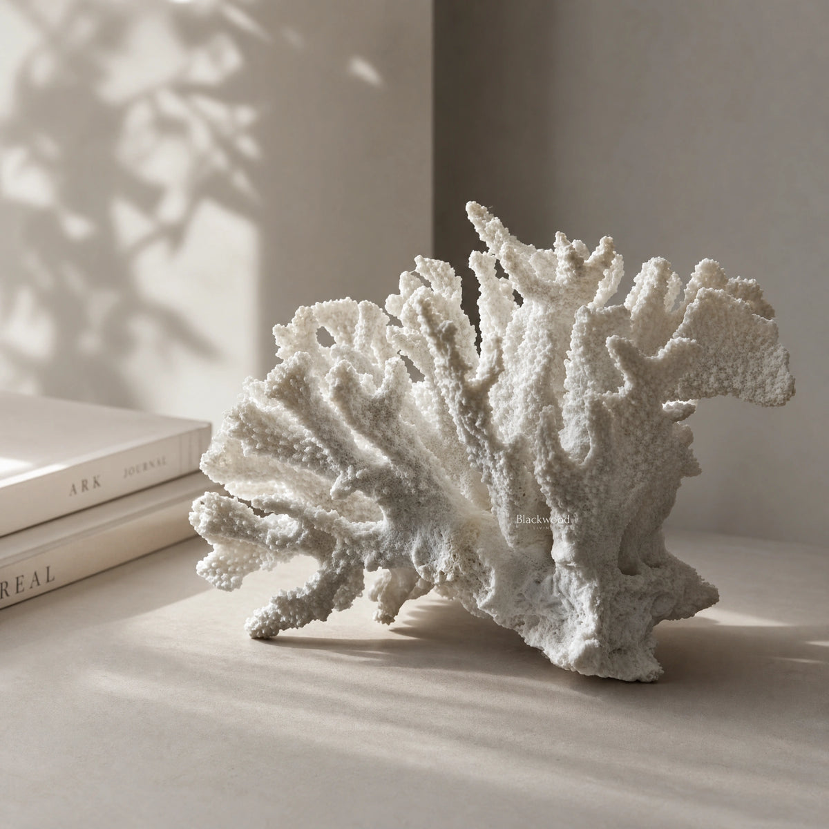 White coral ornament on a shelf; faux coral sculpture in polyresin for coastal decor.