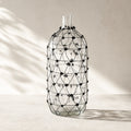 Salvage wired glass vase with wrapped black wire lattice on clear glass.