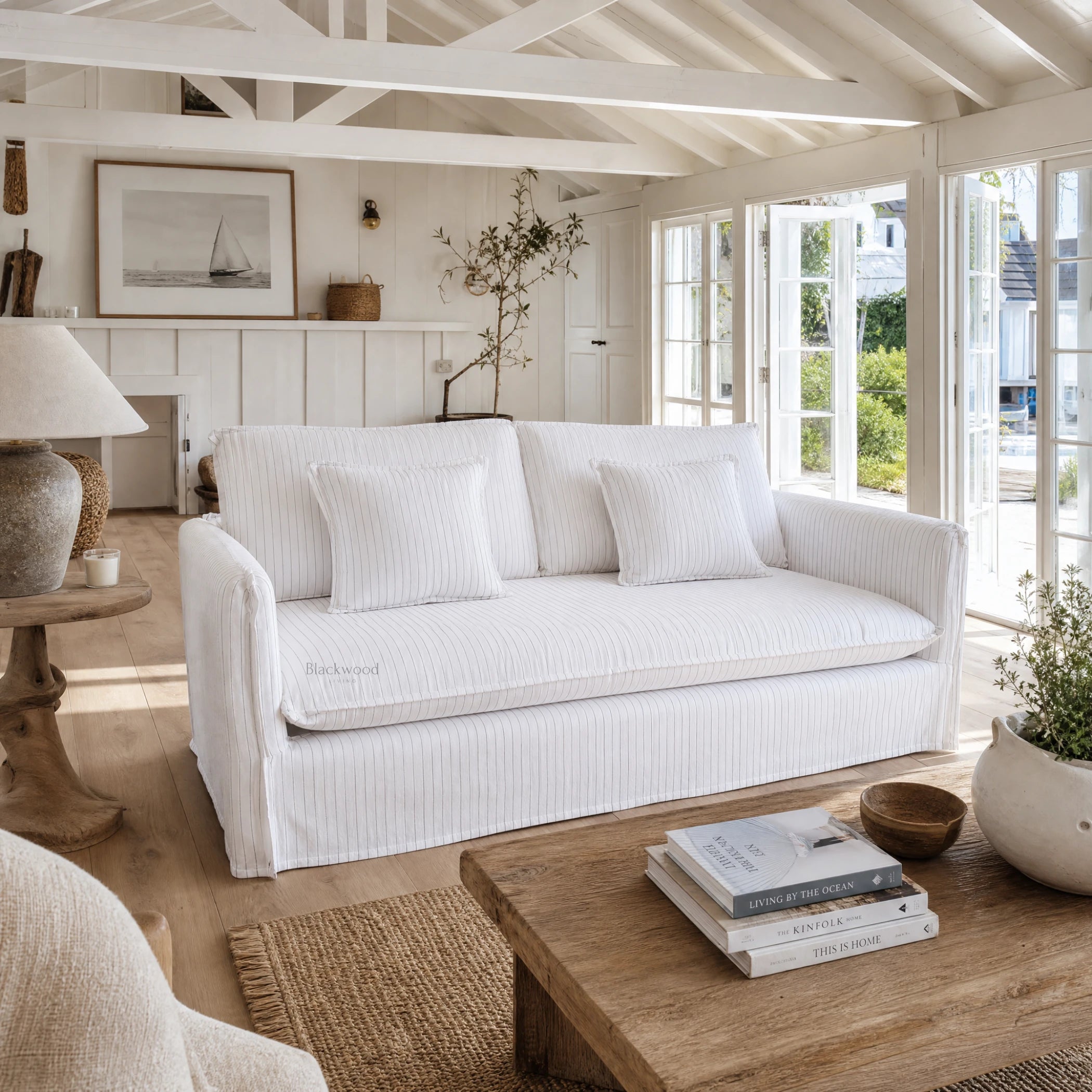Nantucket Slipcover Sofa in a sunlit coastal living room with a linen-cotton blend slipcover in grey pinstripes.