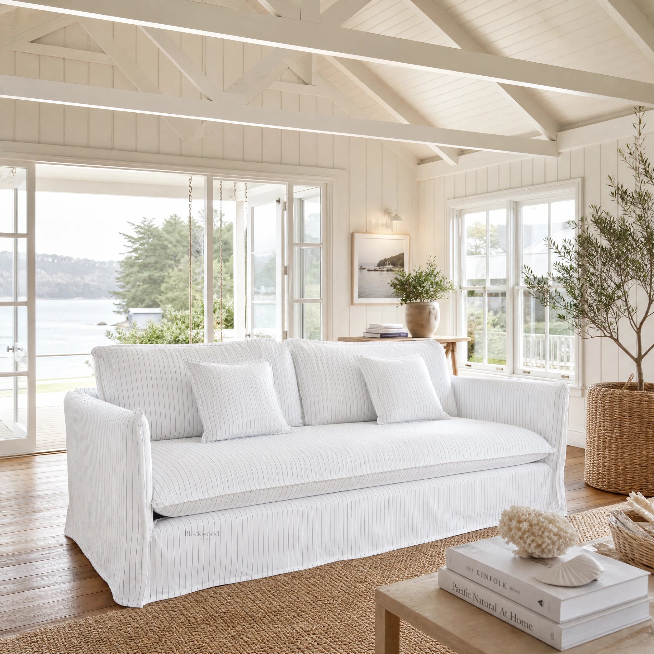 Nantucket Slipcover 3 Seat Sofa in light linen with grey pinstripes, in a sunlit coastal living room.