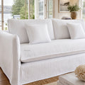 Nantucket slipcover 3-seat sofa in light linen with grey pinstripes against a sunlit coastal living room.