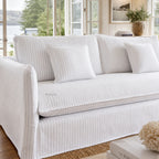 Nantucket slipcover 3-seat sofa in light linen with grey pinstripes against a sunlit coastal living room.