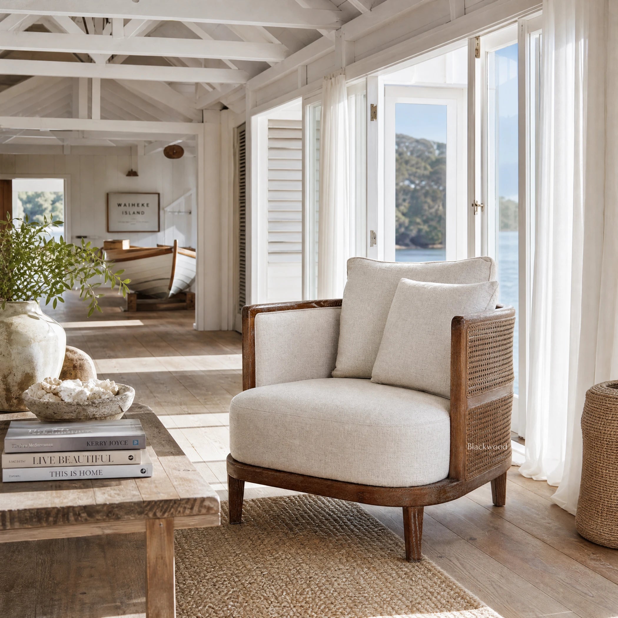 Seabrooke Chair with solid oak frame, handwoven rattan panels, and linen upholstery in a bright coastal living space.
