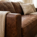 Grange Leather 3 Seat Sofa in warm brown leather with a beige knitted throw.