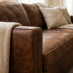 Grange Leather 3 Seat Sofa in warm brown leather with a beige knitted throw.