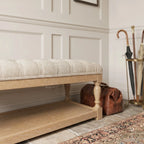 Oakfield Bench with sculpted oak frame and tailored tufted upholstery in a warm, classic setting.