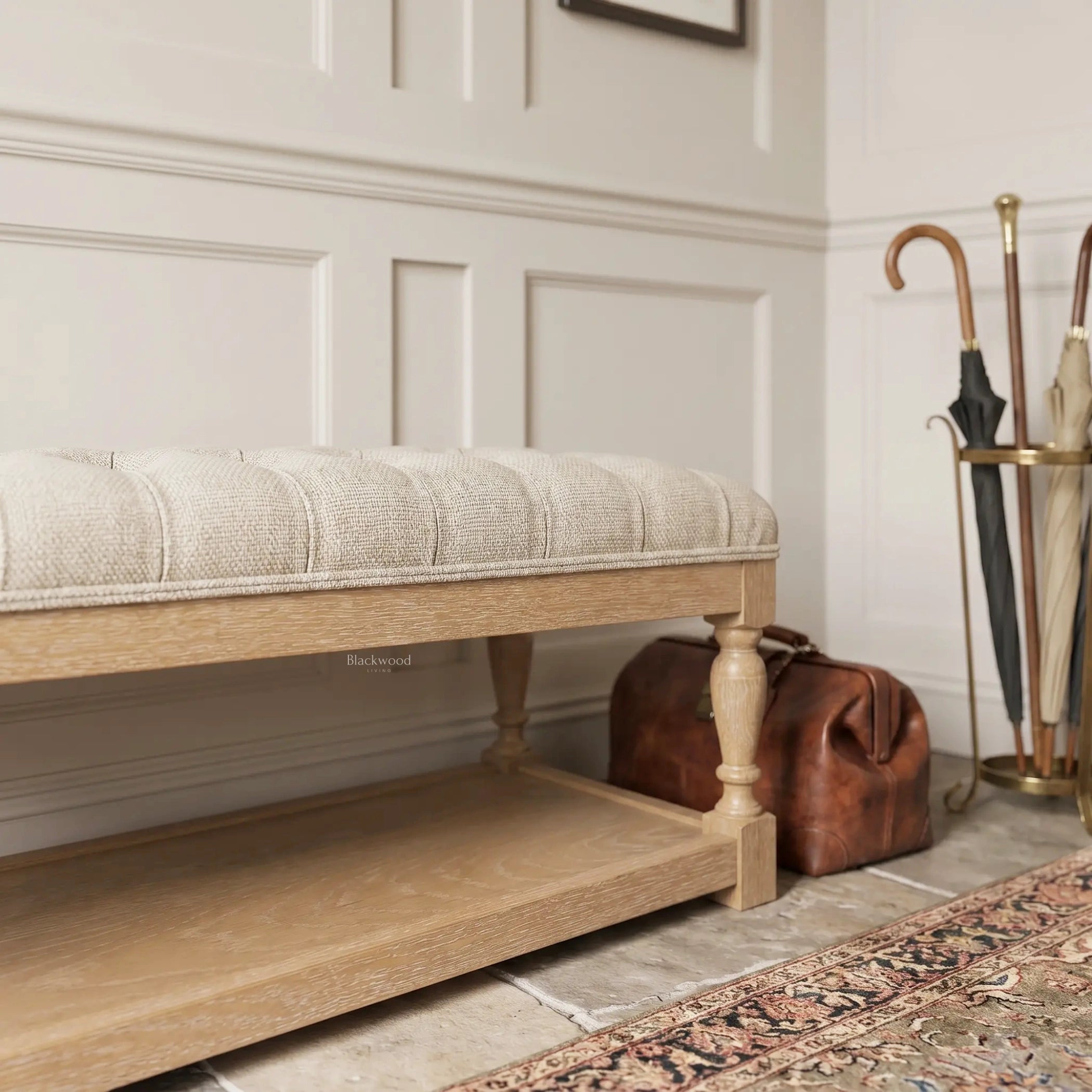 Oakfield Bench with sculpted oak frame and tailored tufted upholstery in a warm, classic setting.