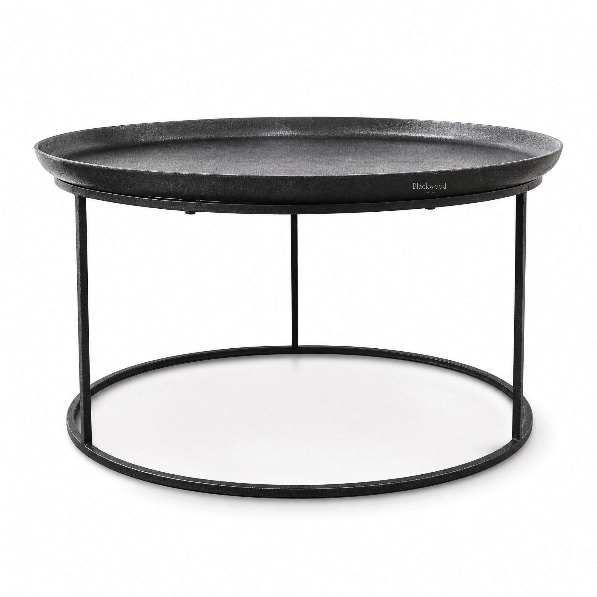Round antique black coffee table with raised tray-style aluminium top and slender iron frame base for plantation-inspired interiors.