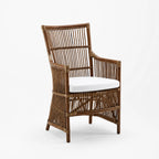 Sika Design DaVinci rattan armchair with sculptural high back, generous arms, and white cushion on white background.