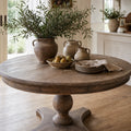 Laurent round reclaimed elm dining table styled with rustic ceramics, greenery, and stone plates.