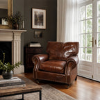Brown Churchill leather armchair with studded detailing in a classic room with fireplace.