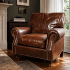 Brown leather Churchill armchair with brass stud detailing in traditional living room.