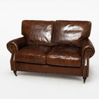 Antique brown South American leather two-seater Churchill sofa with rolled arms, nailhead trim, and wood legs.
